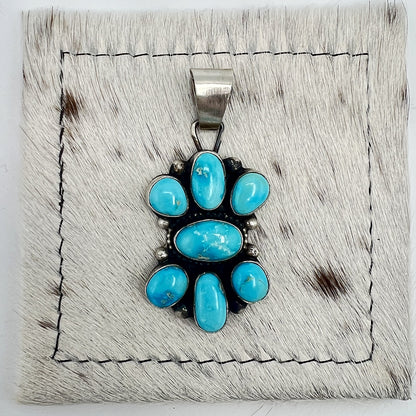 Front view of Sheila Becenti Blue Bird turquoise cluster pendant with wide silver bail
