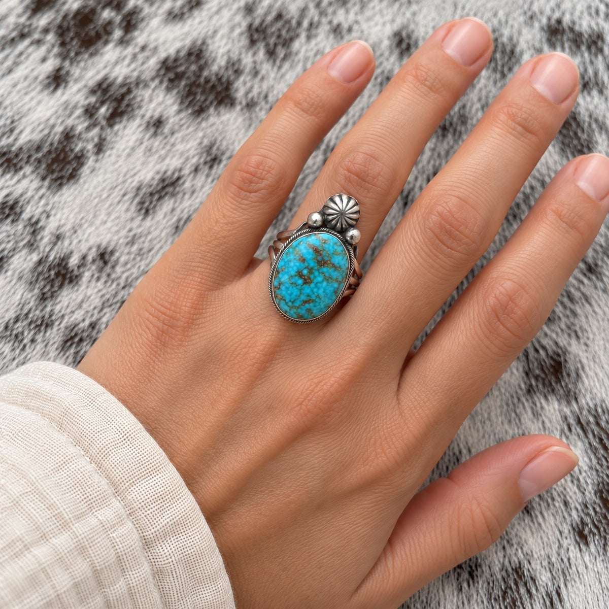 Kingman Turquoise Oval Ring worn around a finger; approximate scale